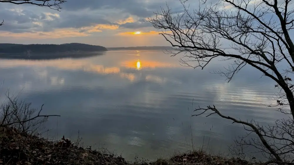 Sonnenuntergang. Die güldene Wintersonne spiegelt sich im grauen Wasser der Ostsee.