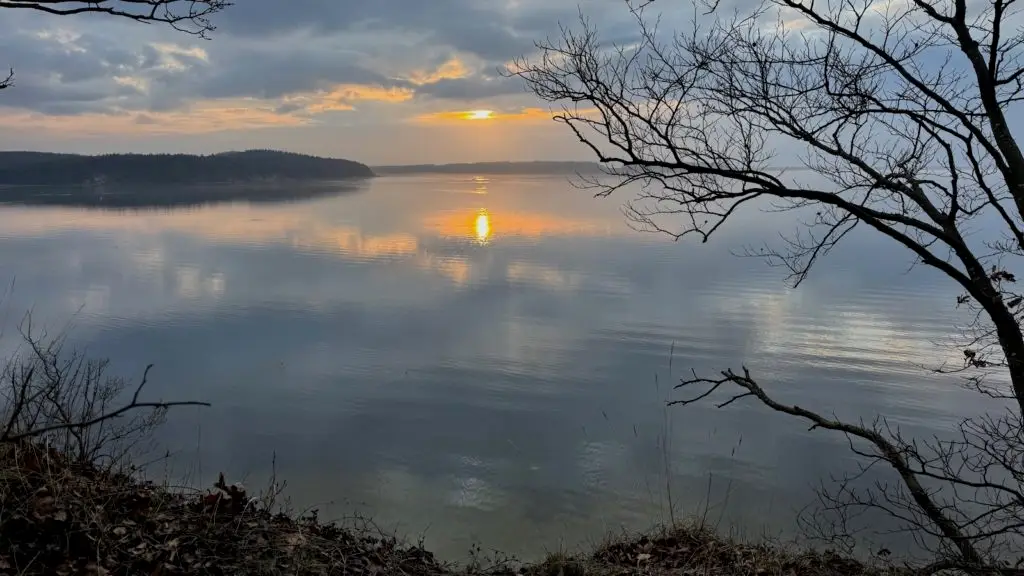 Sonnenuntergang. Die güldene Wintersonne spiegelt sich im grauen Wasser der Ostsee.