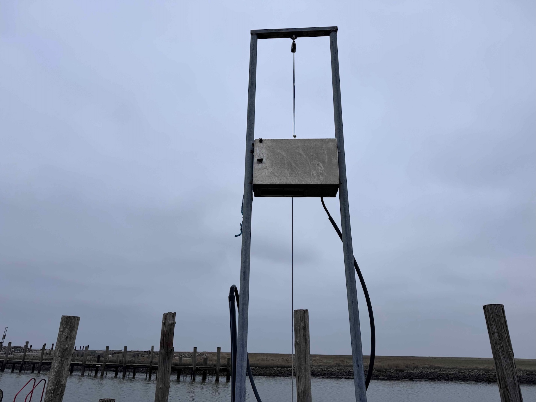 Stromkasten auf Hallig Hooge in einem hochziehbaren Metallgestell am Hafen, konstruiert für Sturmfluten und „Landunter“.