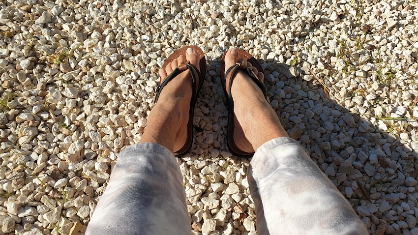 Füße in Sandalen auf hellem Kiesweg als Symbol für Aufbruch und persönliche Lebensreise