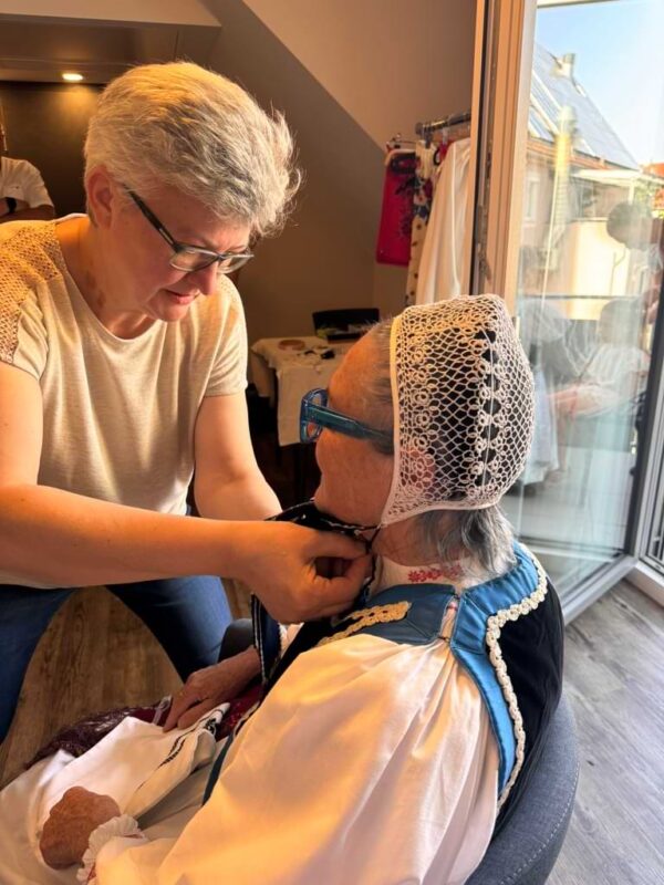 Ankleideszene beim Heimattag der Siebenbürger Sachsen: Eine Frau hilft der Autorin Irmgard Rosina beim Anlegen der traditionellen siebenbürgisch-sächsischen Tracht beim Heimattag in Dinkelsbühl.