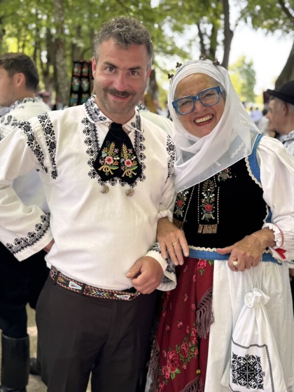 Autorin Irmgard Rosina mit ihrem Sohn Philipp beim Heimattag der Siebenbürger Sachsen in Dinkelsbühl. Beide tragen traditionelle siebenbürgisch-sächsische Tracht der HOG Gergeschdorf und stehen lächelnd nebeneinander.
