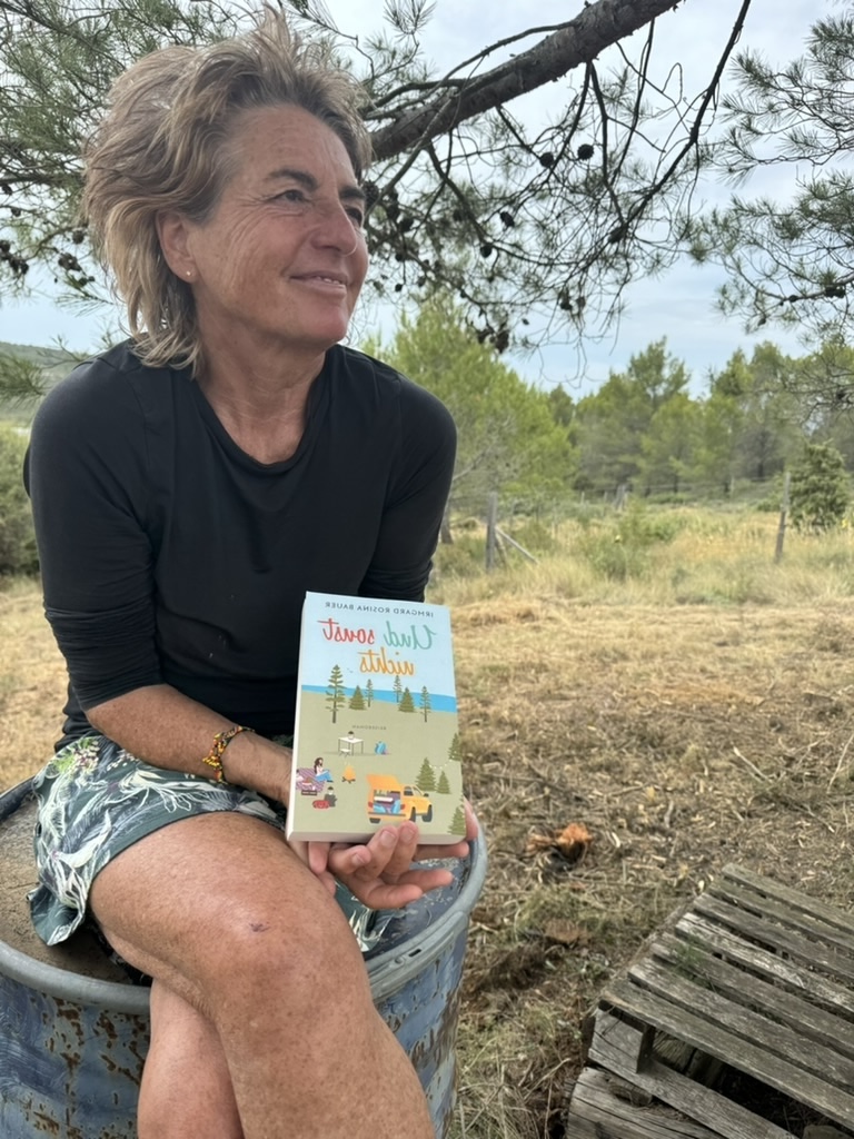 Die Hörbuchsprecherin Fine Thurmond lässt das Hörbuchcover mit Titel "Und sonst nichts" über sich schweben und zeigt darauf.