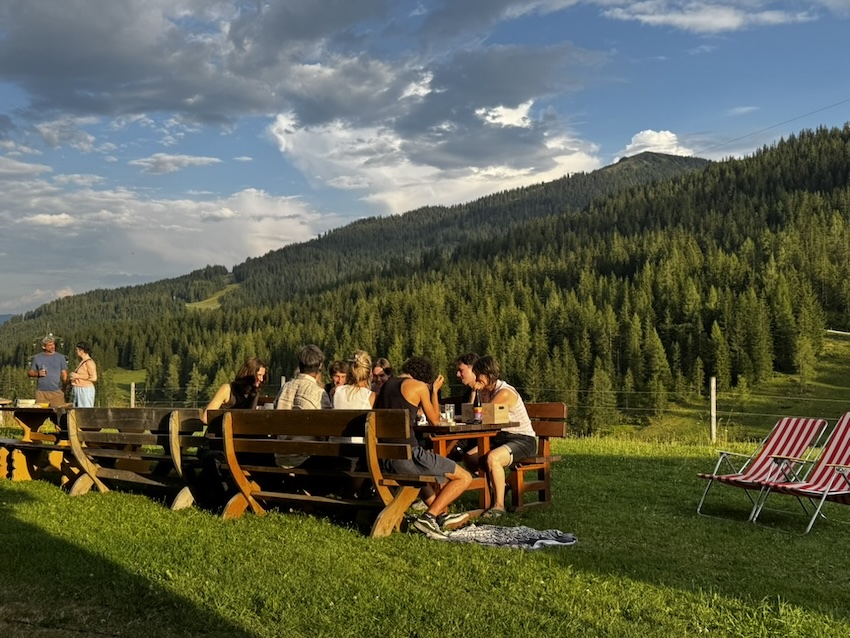 Familie und Freunde beim gemeinsamen Essen vor der Berghütte während der 20/70-Festwoche