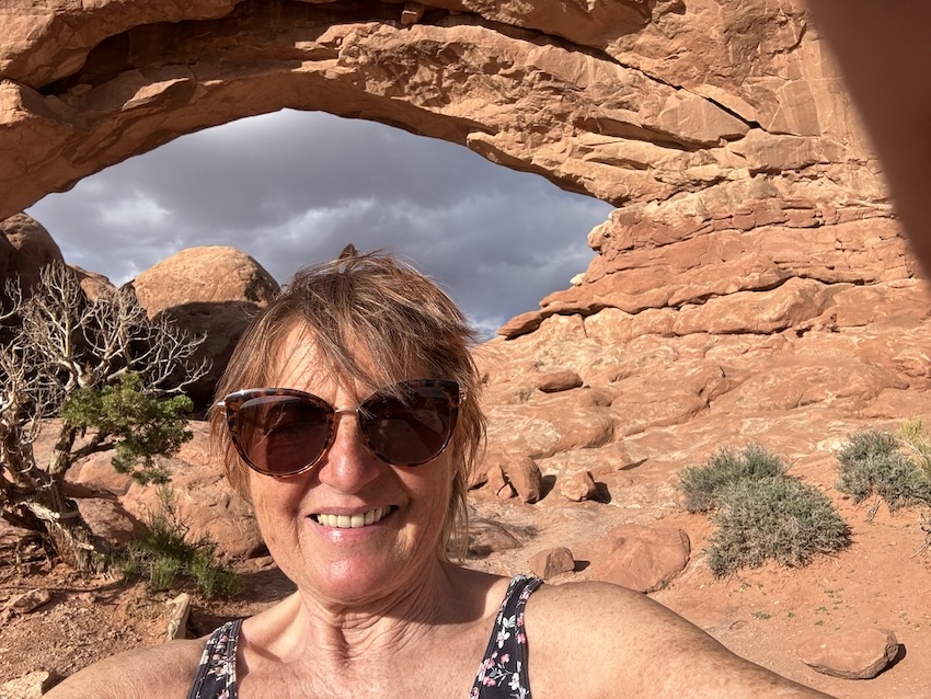 Irmgard Rosina auf Reisen unter einem roten Felsbogen im sommerlichen Archespark im Südwesten der USA