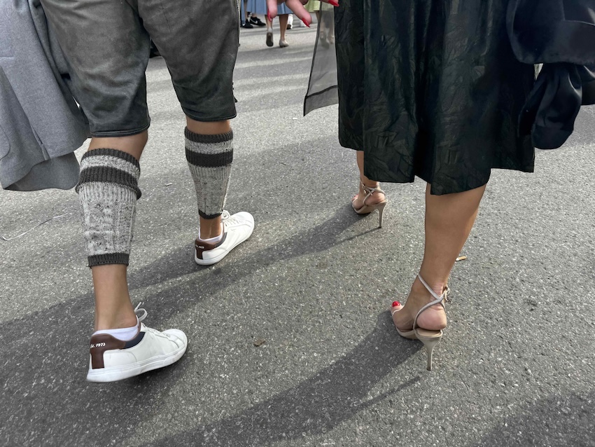 Beine von Oktoberfestbesuchern in Tracht mit Haferlschuhen, Loferln und Dirndlschuhen auf der Münchner Wiesn.